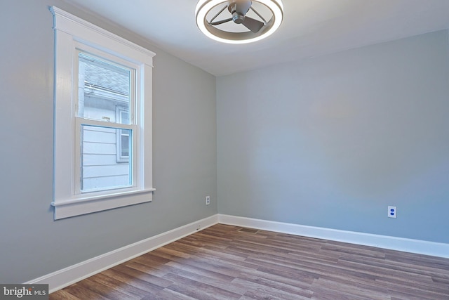 empty room with baseboards and dark wood-type flooring