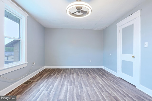 empty room with baseboards, a ceiling fan, and wood finished floors