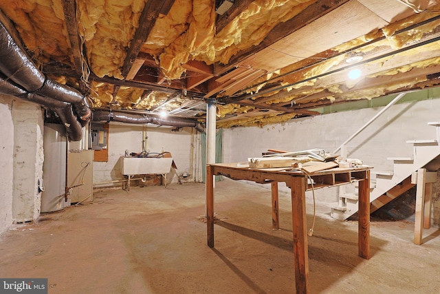 unfinished below grade area featuring a sink, stairway, and electric panel