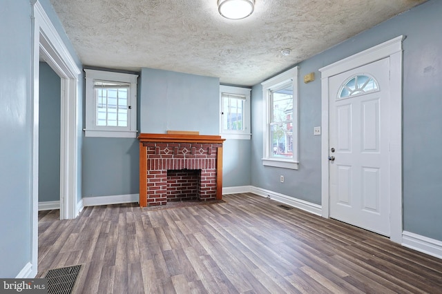 entrance foyer with baseboards, wood finished floors, and visible vents