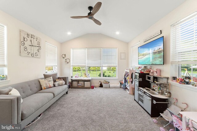 living room with ceiling fan, carpet, vaulted ceiling, and a wealth of natural light