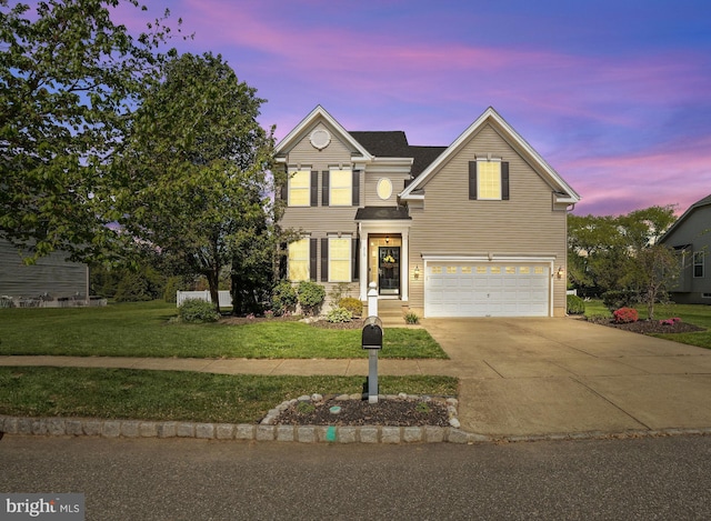 traditional-style house with a lawn, an attached garage, and concrete driveway