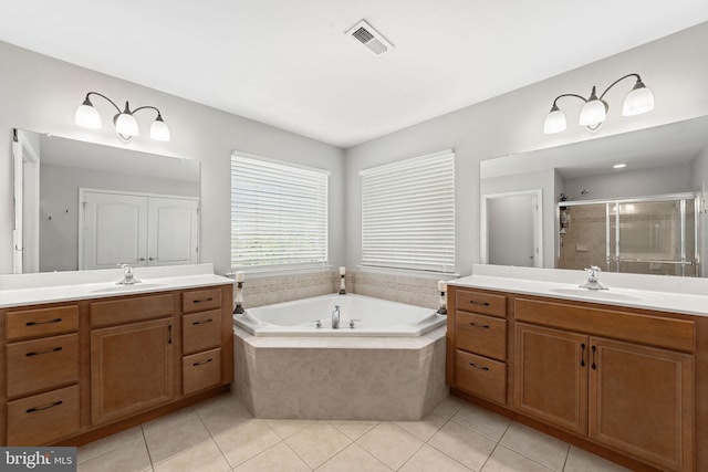 bathroom featuring two vanities, a sink, a bath, and a stall shower