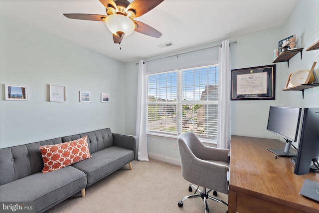 home office with baseboards, ceiling fan, light carpet, and visible vents