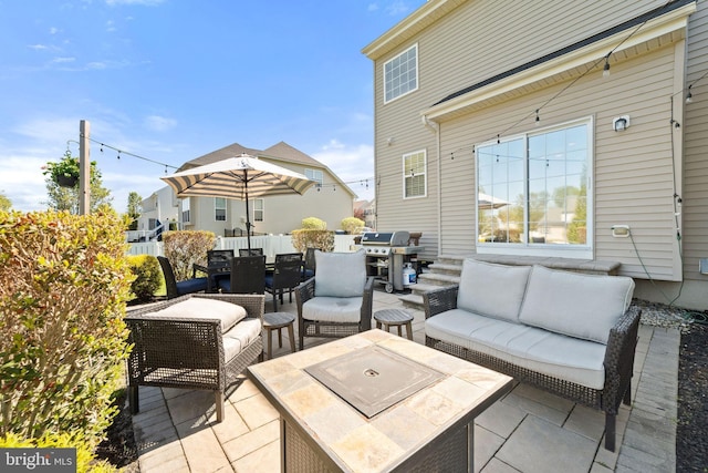 view of patio / terrace featuring area for grilling, outdoor dining space, and an outdoor living space with a fire pit