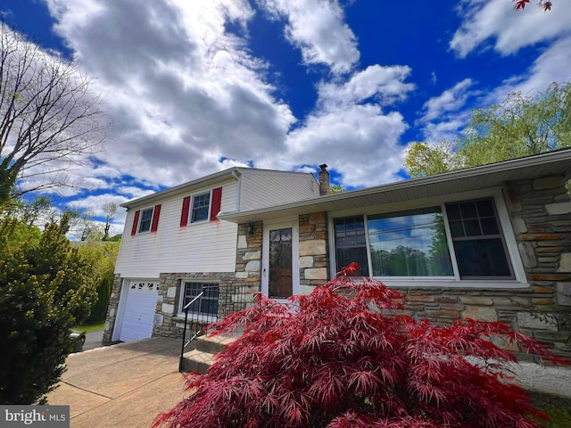 300 Rockledge Ave, Huntingdon Valley, PA 19006 - tri-level home featuring a garage, a chimney, driveway, and stone siding