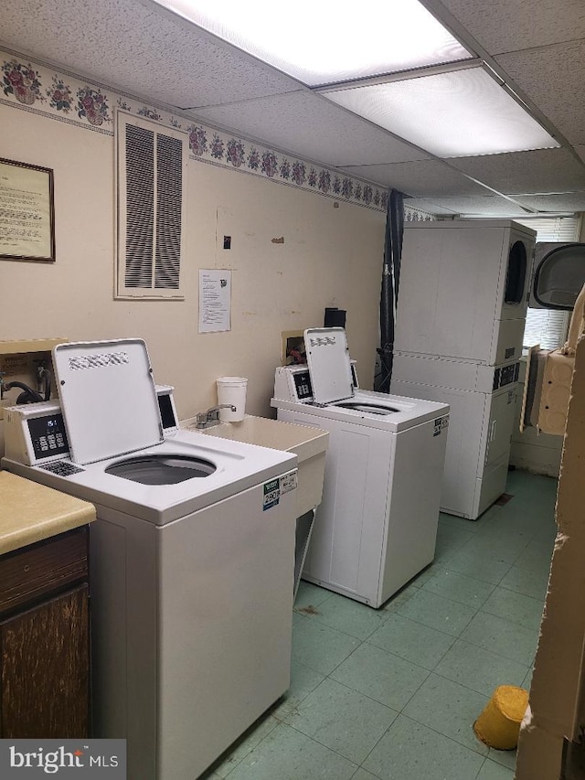 common laundry area with light floors and washing machine and clothes dryer