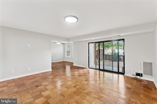 unfurnished room featuring baseboards, visible vents, and ceiling fan