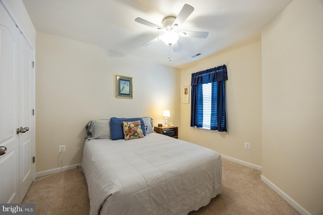 bedroom with visible vents, baseboards, ceiling fan, and light carpet
