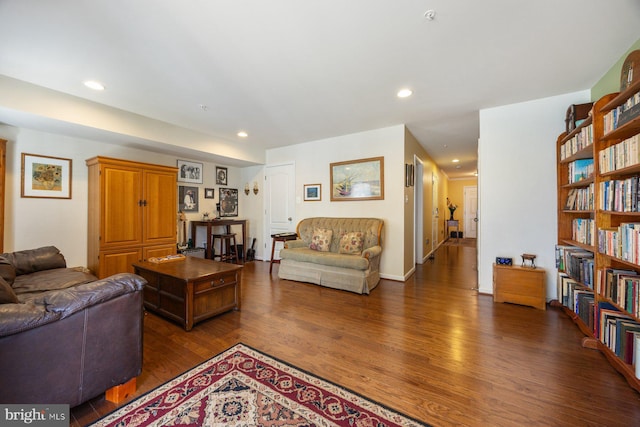 living room with recessed lighting and dark wood-type flooring