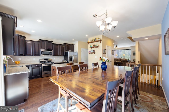 dining space with dark wood-type flooring, recessed lighting, and ceiling fan with notable chandelier