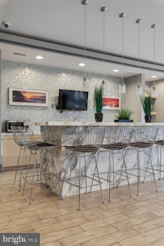 bar featuring light wood-style floors, decorative light fixtures, recessed lighting, and visible vents