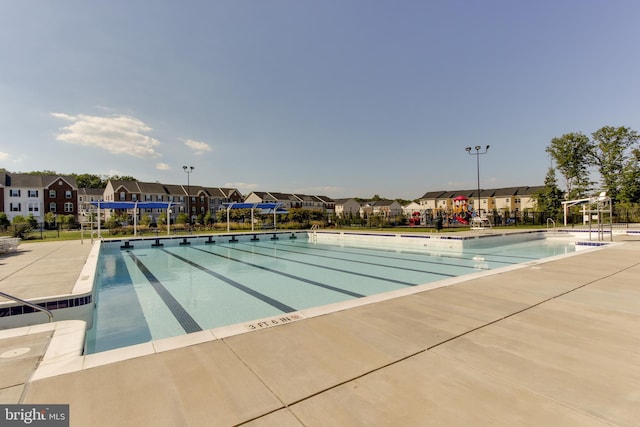 community pool with a patio and a residential view