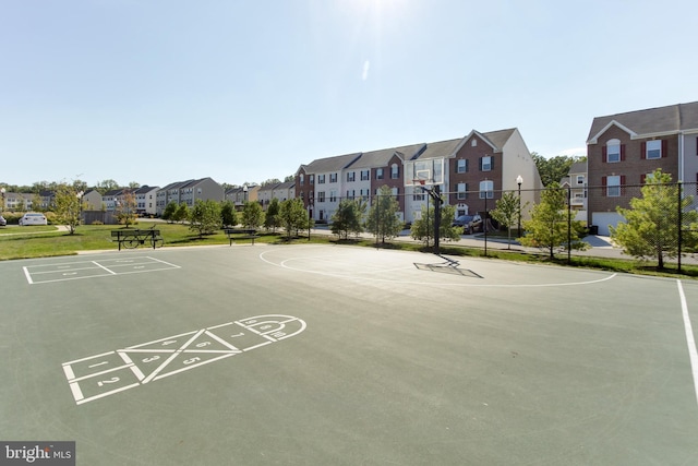 view of sport court with community basketball court, fence, and a residential view