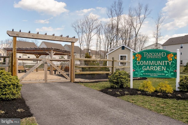 view of property's community featuring fence and a gate