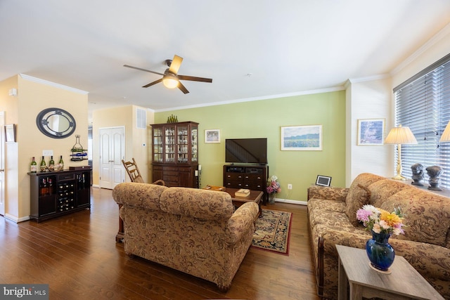 living room with crown molding, ceiling fan, baseboards, and dark wood-type flooring