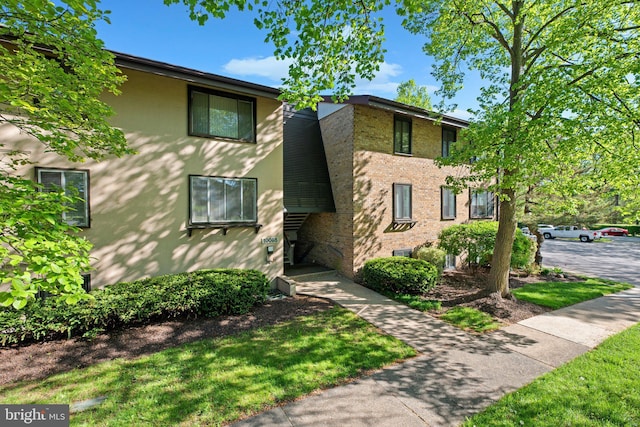 view of front facade featuring stucco siding and brick siding