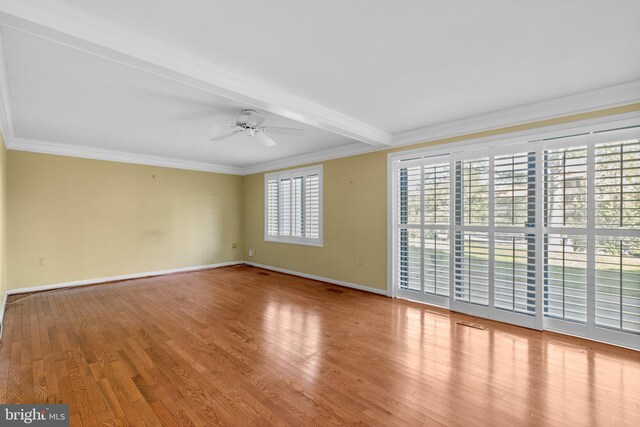 interior space with a ceiling fan, baseboards, wood finished floors, and beam ceiling