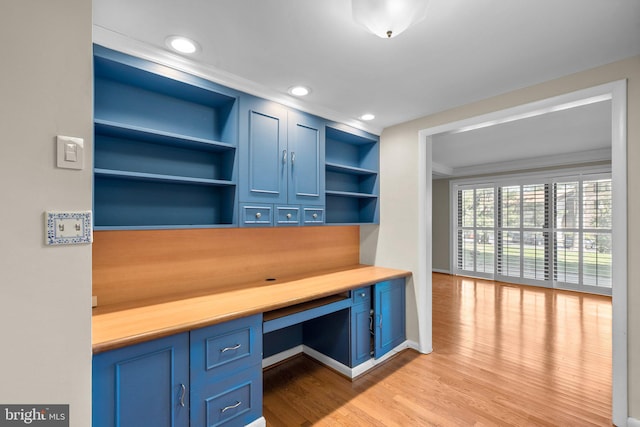 unfurnished office featuring built in study area, recessed lighting, baseboards, wood finished floors, and ornamental molding