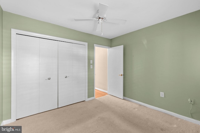 unfurnished bedroom with baseboards, a ceiling fan, carpet, and a closet