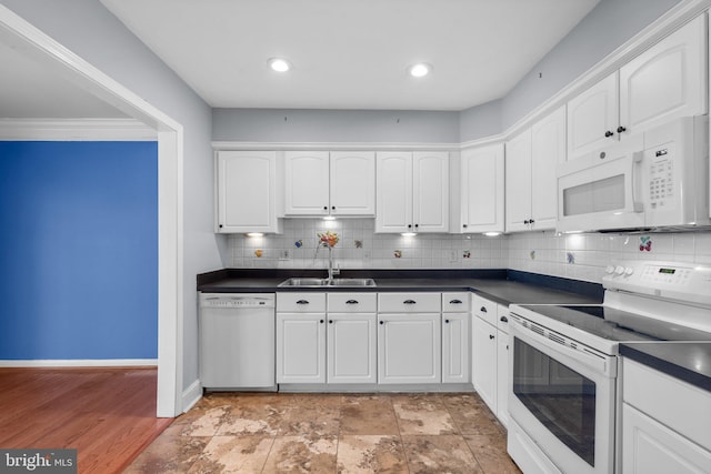 kitchen featuring white appliances, white cabinetry, dark countertops, and a sink