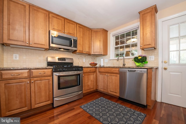 3004 Joshua Rd, Lafayette Hill, PA 19444 - kitchen featuring dark wood-style flooring, light stone countertops, appliances with stainless steel finishes, and decorative backsplash