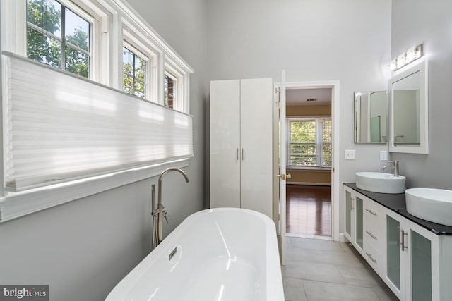 5811 Summerlake Way, Centreville, VA 20120 - bathroom featuring tile patterned flooring, double vanity, a high ceiling, a freestanding bath, and a sink