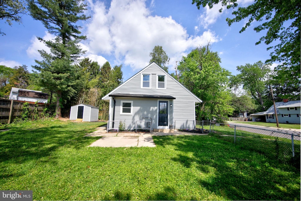 back of property with a patio, an outbuilding, a fenced backyard, and a storage unit