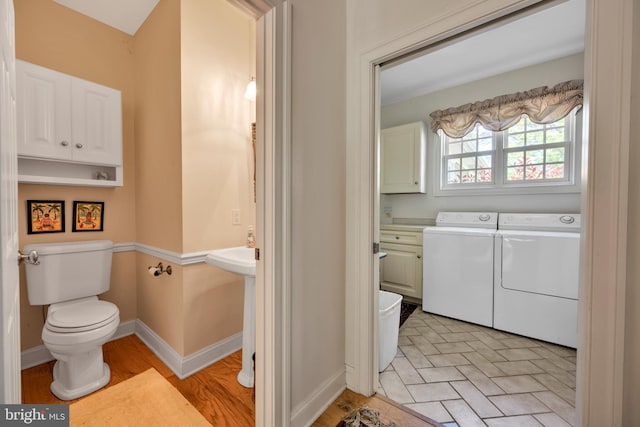 bathroom with washer and clothes dryer, toilet, and baseboards