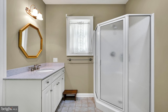 full bath featuring a shower stall, vanity, baseboards, and tile patterned flooring