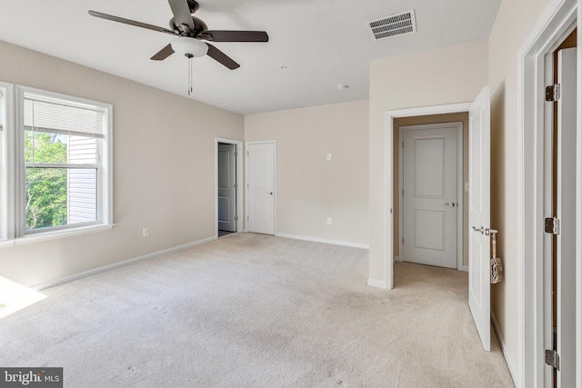 unfurnished bedroom featuring visible vents, a ceiling fan, baseboards, and light colored carpet