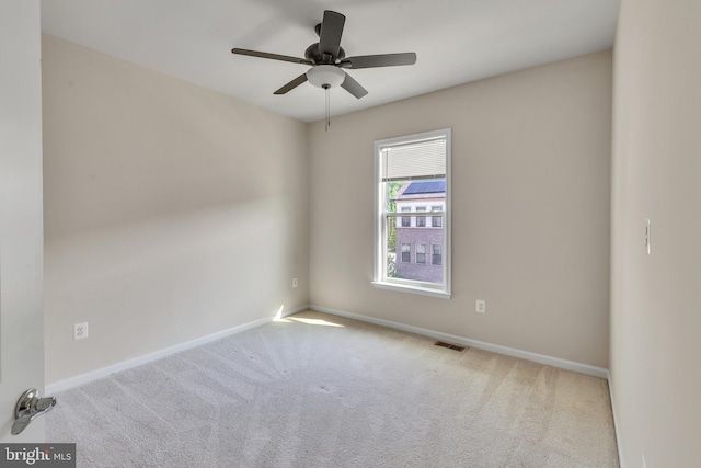 spare room with baseboards, a ceiling fan, carpet floors, and visible vents