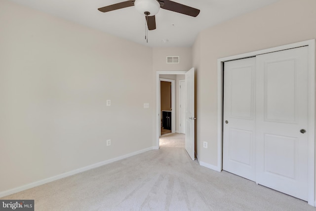 unfurnished bedroom with ceiling fan, light carpet, baseboards, visible vents, and a closet