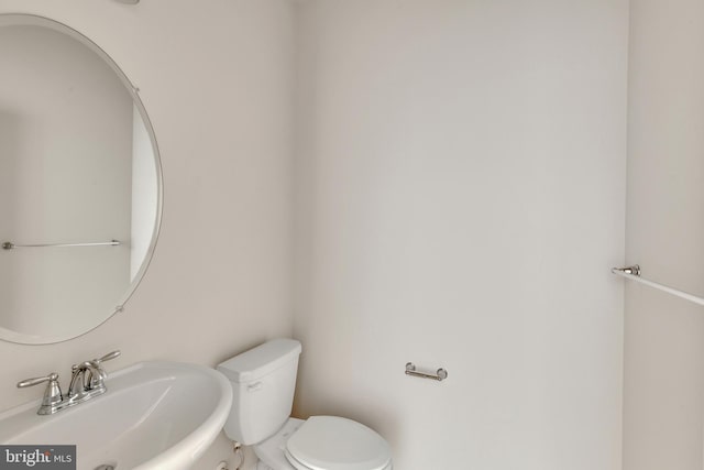 half bath featuring toilet and a sink