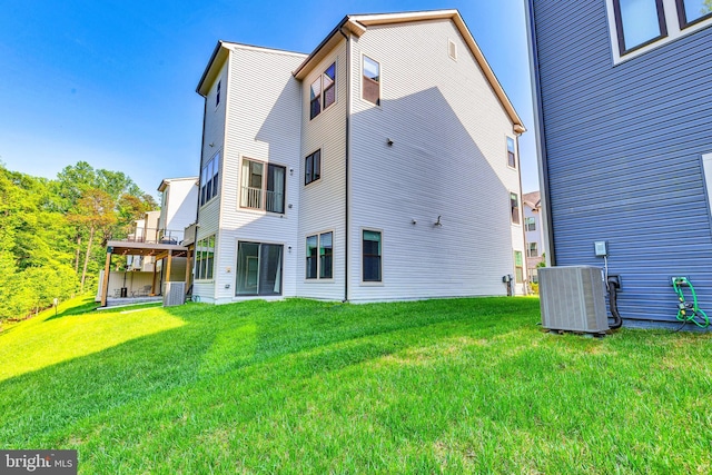back of property with a lawn and central AC