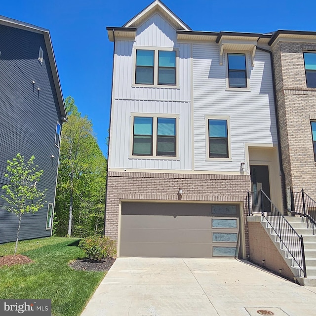 multi unit property with a garage, board and batten siding, concrete driveway, and brick siding