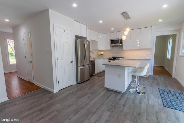 kitchen featuring appliances with stainless steel finishes, modern cabinets, baseboards, and white cabinetry