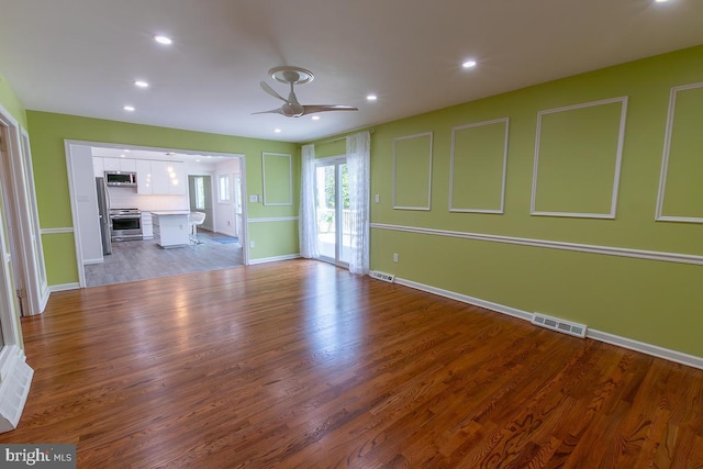 unfurnished living room featuring a ceiling fan, recessed lighting, wood finished floors, and visible vents