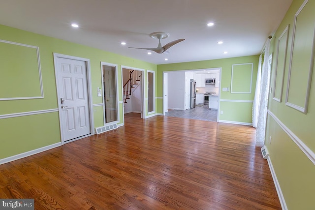 interior space featuring stairs, recessed lighting, baseboards, wood finished floors, and visible vents