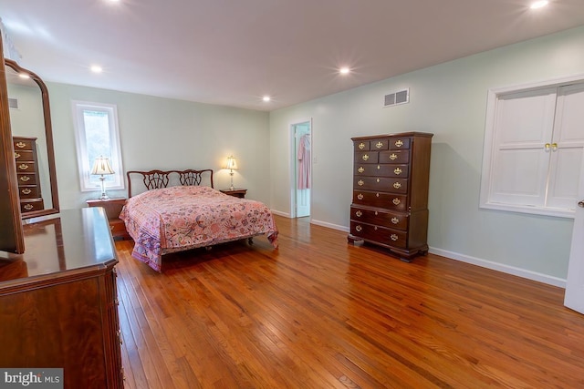 bedroom with baseboards, wood-type flooring, recessed lighting, and visible vents