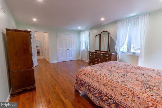 bedroom with visible vents, wood finished floors, baseboards, a closet, and recessed lighting