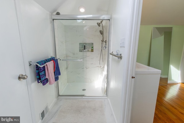 full bathroom featuring baseboards, visible vents, a marble finish shower, and wood finished floors