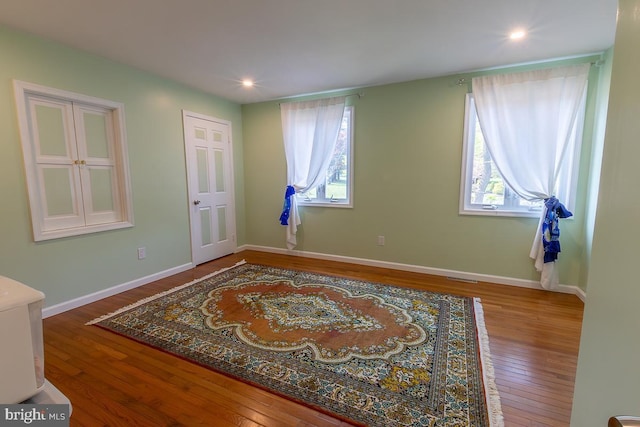 interior space featuring baseboards, multiple windows, recessed lighting, and wood finished floors