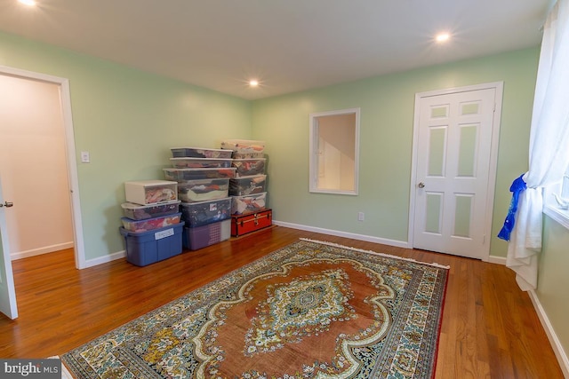 interior space with baseboards, recessed lighting, and wood finished floors
