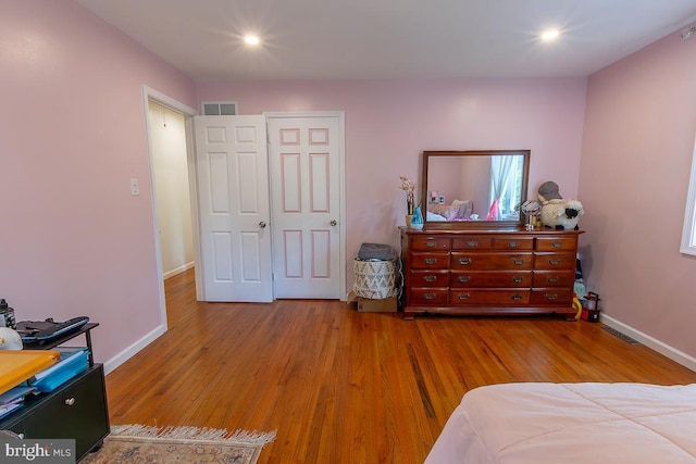 bedroom with recessed lighting, baseboards, visible vents, and wood finished floors