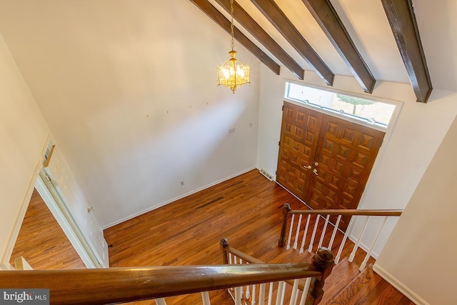 entryway with an inviting chandelier, vaulted ceiling with beams, wood finished floors, and visible vents