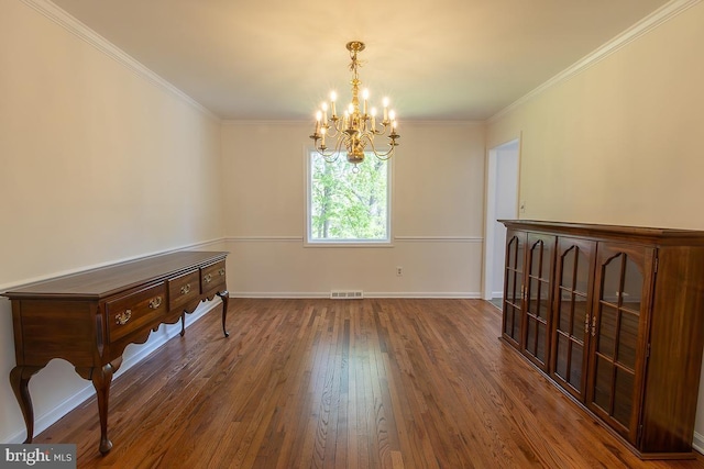 unfurnished dining area featuring visible vents, ornamental molding, wood finished floors, and a chandelier
