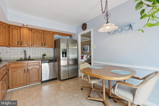 315 Waverly Rd, Southampton, PA 18966 - kitchen with stainless steel appliances, a sink, decorative backsplash, brown cabinetry, and pendant lighting
