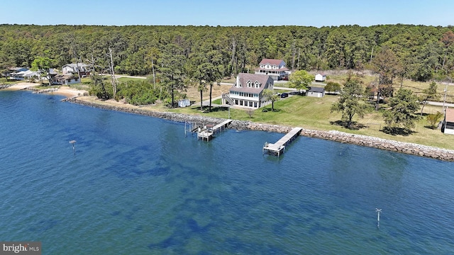 drone / aerial view featuring a forest view and a water view
