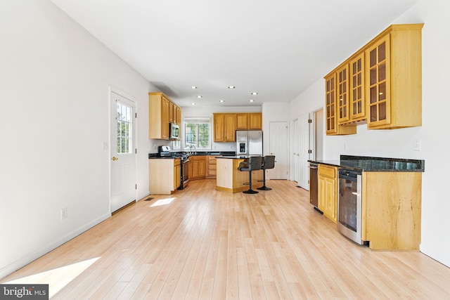 40461 Old Breton Beach Rd, Leonardtown, MD 20650 - kitchen featuring stainless steel appliances, beverage cooler, a kitchen breakfast bar, light wood-style floors, and dark countertops